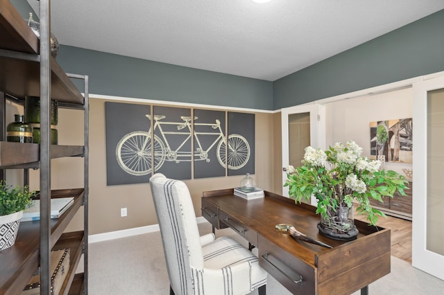 carpeted office space with french doors and a textured ceiling