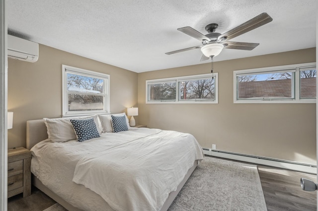 bedroom with ceiling fan, a wall mounted AC, a textured ceiling, and a baseboard heating unit