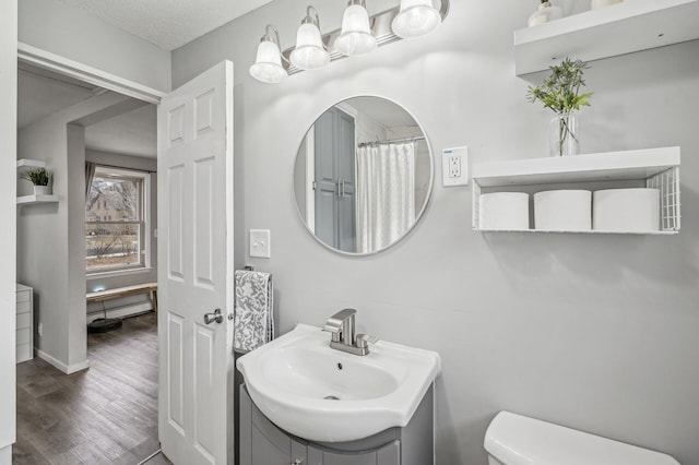 bathroom with vanity, hardwood / wood-style floors, toilet, and a textured ceiling