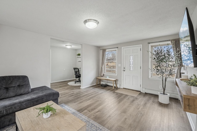 living room with hardwood / wood-style floors, a textured ceiling, and a baseboard heating unit