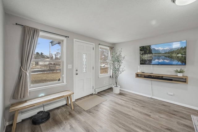 entryway with hardwood / wood-style floors, a textured ceiling, and baseboard heating