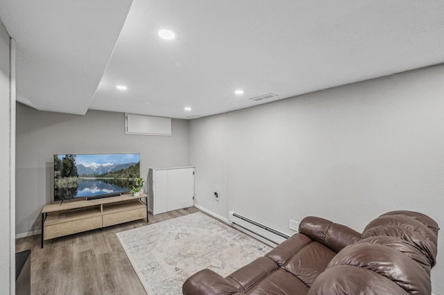 living room with hardwood / wood-style flooring and a baseboard heating unit