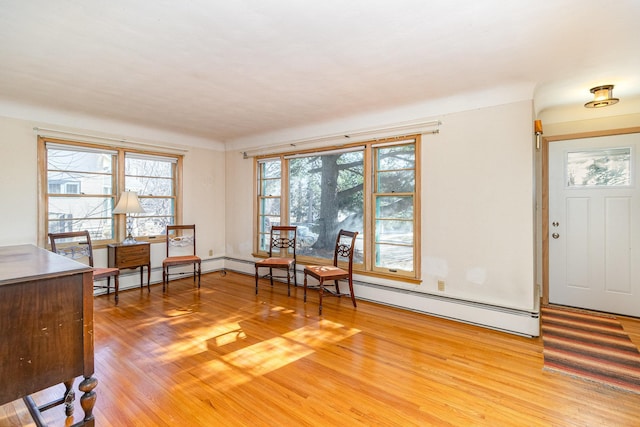 entryway featuring baseboard heating, plenty of natural light, and hardwood / wood-style floors