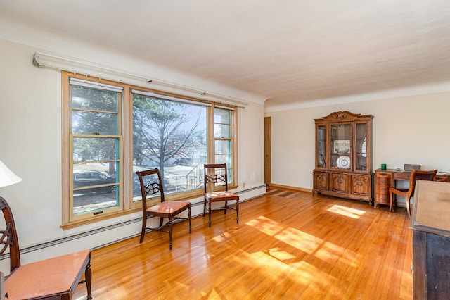 living area with wood-type flooring and a baseboard radiator