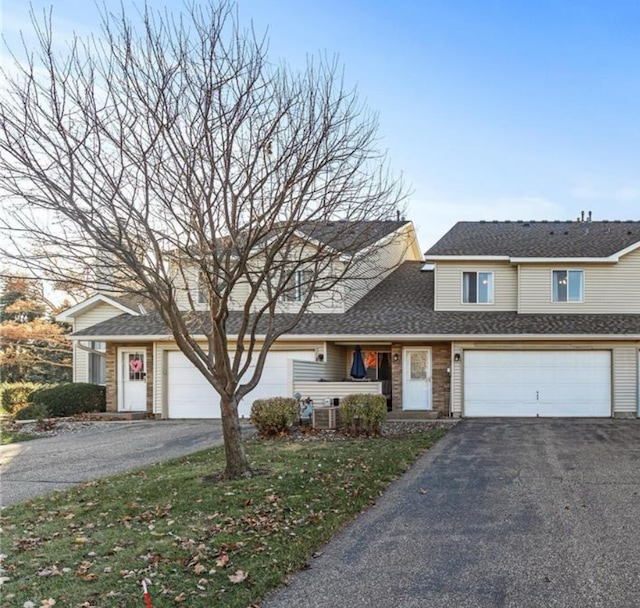 view of property featuring a garage and a front lawn