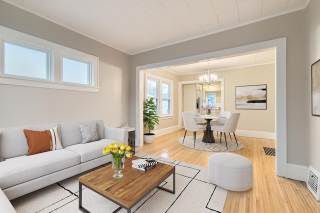 living room with ornamental molding, hardwood / wood-style floors, and a chandelier