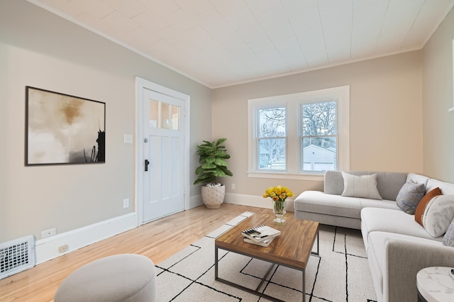 living room with crown molding and light hardwood / wood-style flooring