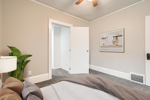 bedroom featuring a textured ceiling, carpet floors, ceiling fan, and crown molding