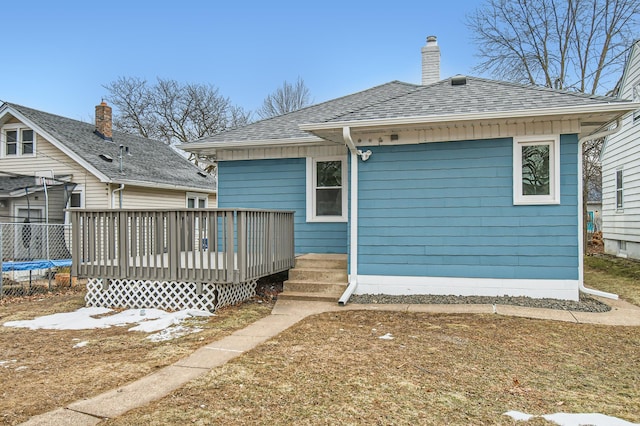 back of house featuring a trampoline and a wooden deck