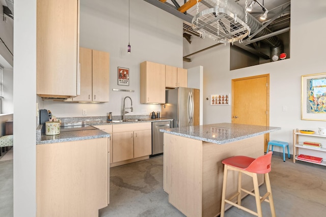 kitchen with sink, a center island, light brown cabinets, a towering ceiling, and appliances with stainless steel finishes