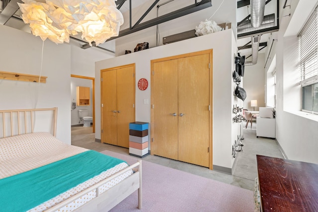 bedroom featuring multiple closets and a high ceiling