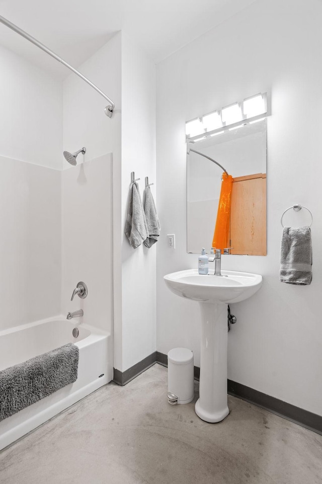 bathroom with sink, concrete floors, and tub / shower combination