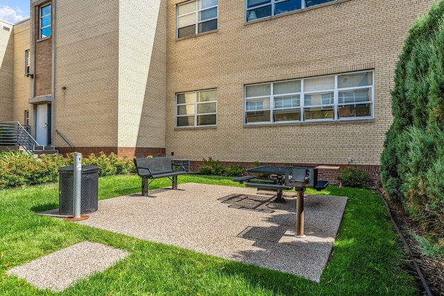 view of property's community with a lawn and a patio area