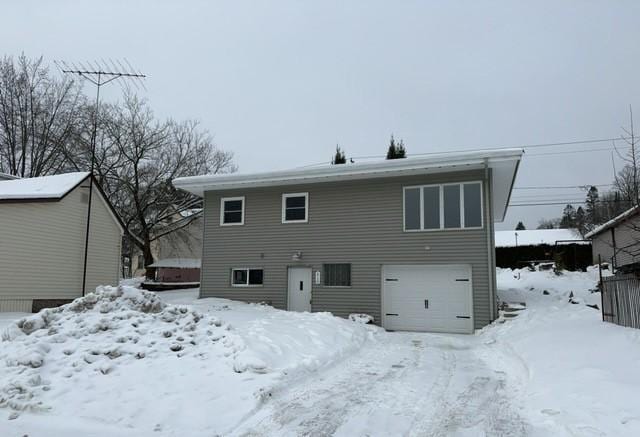 snow covered property featuring a garage