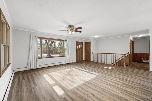 spare room featuring crown molding, light hardwood / wood-style flooring, and a baseboard heating unit