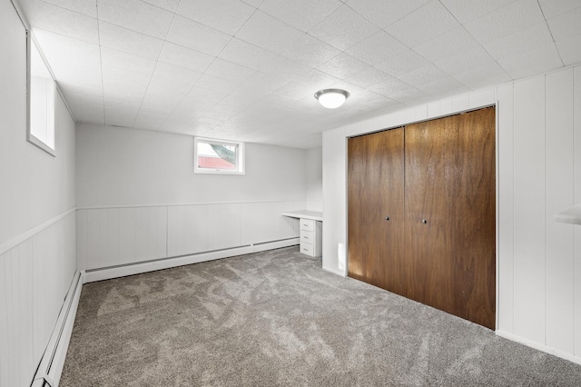 basement featuring baseboard heating and carpet flooring