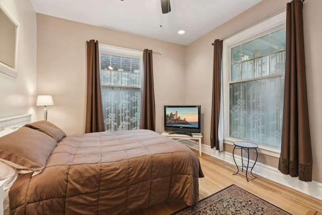 bedroom featuring multiple windows, ceiling fan, and light hardwood / wood-style flooring