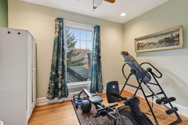 exercise area with ceiling fan and light wood-type flooring