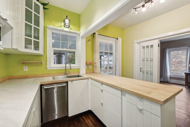 kitchen with kitchen peninsula, sink, dishwasher, white cabinetry, and plenty of natural light