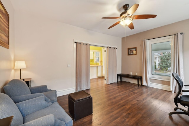 living room featuring ceiling fan and dark wood-type flooring