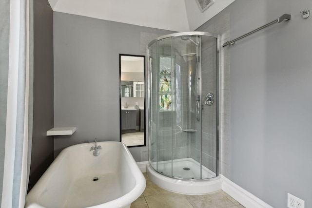 bathroom featuring plus walk in shower, vanity, and tile patterned flooring