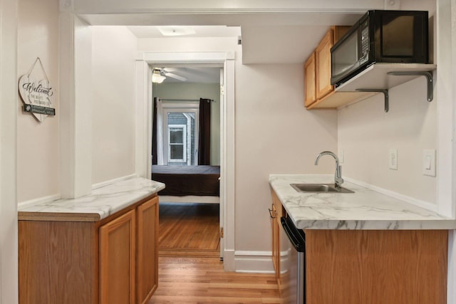 kitchen featuring stainless steel dishwasher, ceiling fan, light hardwood / wood-style floors, and sink