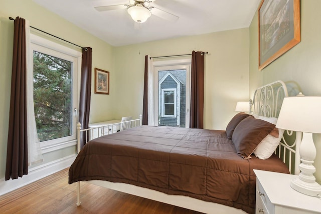 bedroom featuring multiple windows, ceiling fan, and wood-type flooring