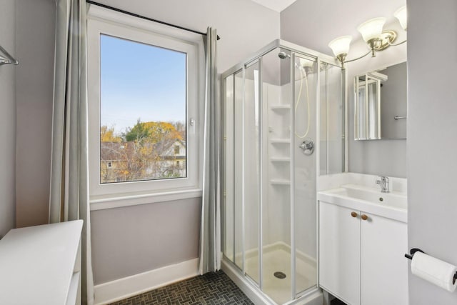 bathroom featuring vanity, a healthy amount of sunlight, and a shower with door