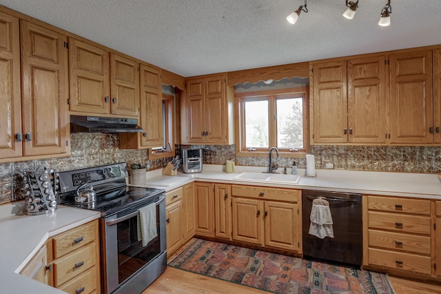 kitchen featuring black dishwasher, light countertops, stainless steel electric range oven, and a sink