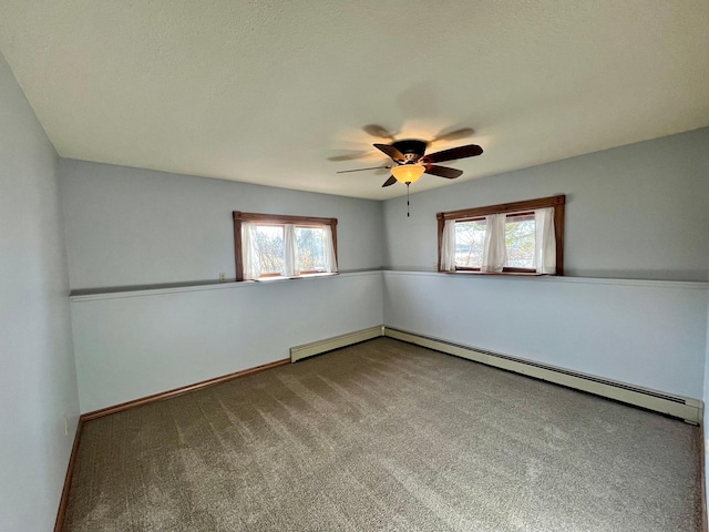 carpeted empty room with a baseboard radiator, baseboards, and a ceiling fan