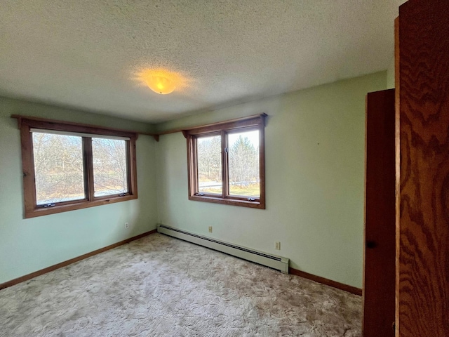 empty room with baseboards, baseboard heating, and light colored carpet