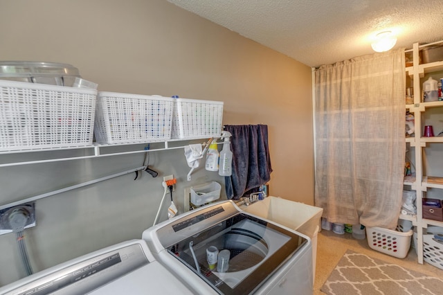 laundry area featuring laundry area, light carpet, independent washer and dryer, and a textured ceiling