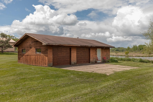 back of house with a yard, an outdoor structure, and a detached garage