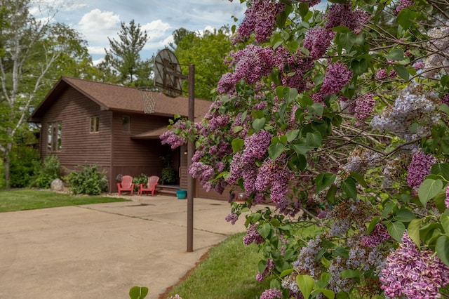 view of side of home featuring a patio and concrete driveway