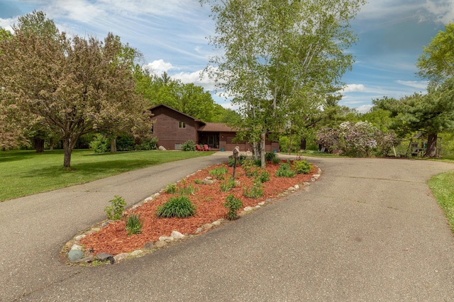 ranch-style house featuring aphalt driveway and a front yard