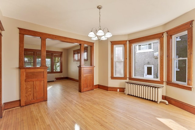 interior space featuring a chandelier, radiator heating unit, and light wood-type flooring