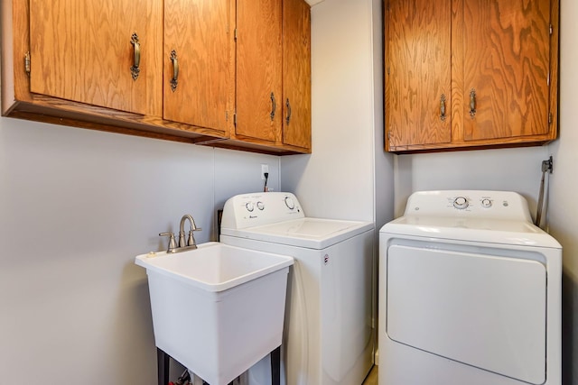 laundry area featuring cabinets, sink, and washing machine and clothes dryer