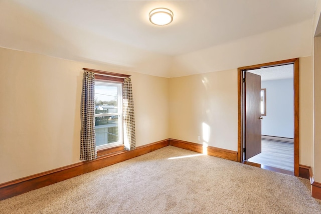 carpeted spare room featuring baseboard heating