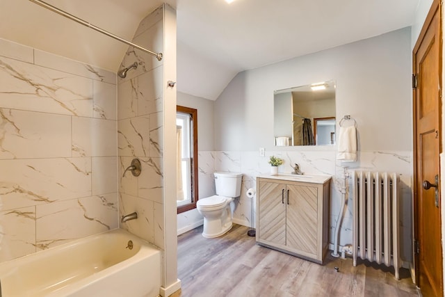 full bathroom featuring vanity, tile walls, radiator heating unit, toilet, and lofted ceiling