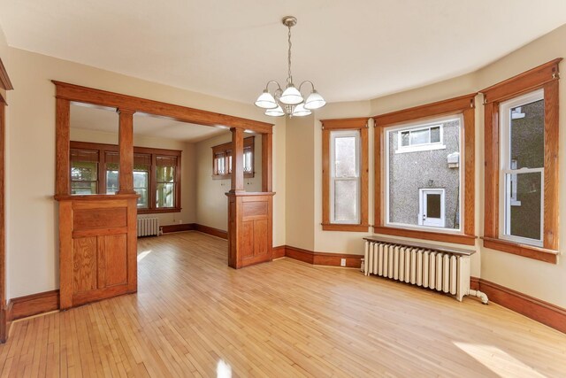 409 Adams St, Arlington, MN 55307 - empty room featuring radiator, light wood finished floors, a chandelier, and baseboards