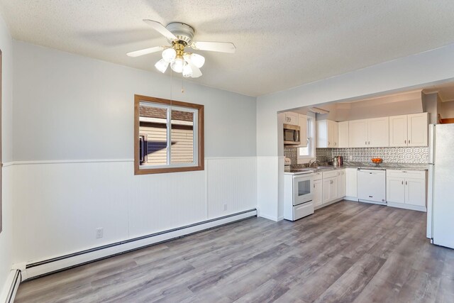 409 Adams St, Arlington, MN 55307 - kitchen with white appliances, baseboard heating, a sink, a wainscoted wall, and a ceiling fan