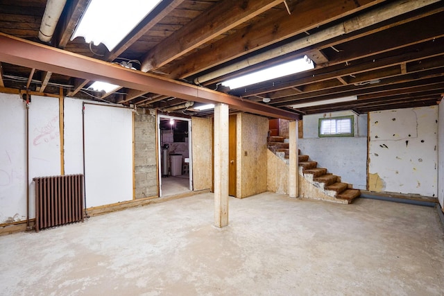 409 Adams St, Arlington, MN 55307 - below grade area featuring radiator heating unit and stairway