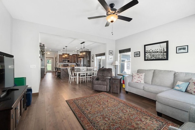 living room with ceiling fan and dark hardwood / wood-style floors