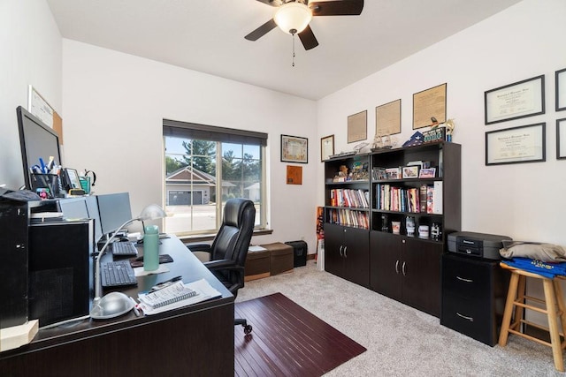 carpeted office space featuring ceiling fan