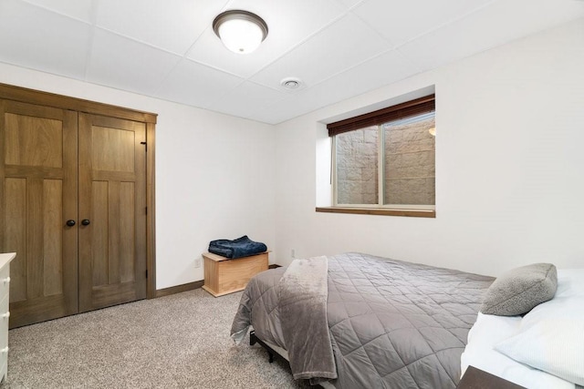 bedroom with a drop ceiling and carpet floors