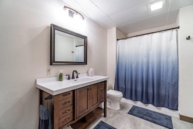 bathroom with hardwood / wood-style floors, vanity, a shower with shower curtain, and toilet