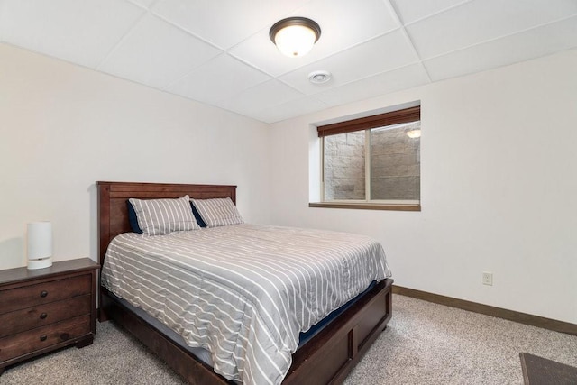 bedroom featuring a paneled ceiling and light colored carpet