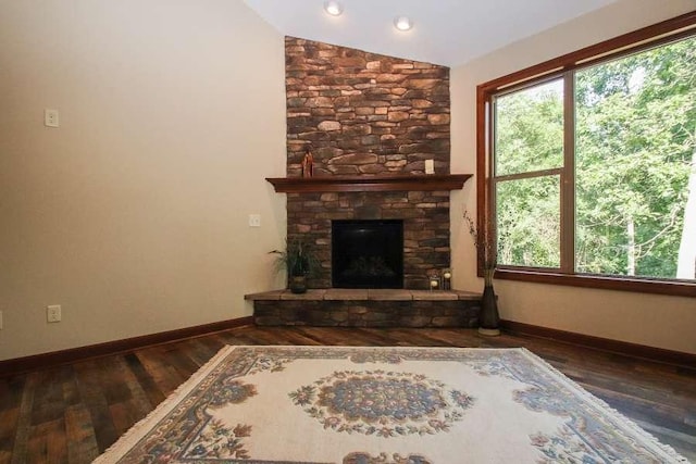 unfurnished living room with dark wood-type flooring, a fireplace, and vaulted ceiling