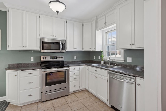 kitchen featuring white cabinetry, stainless steel appliances, light tile patterned flooring, and sink