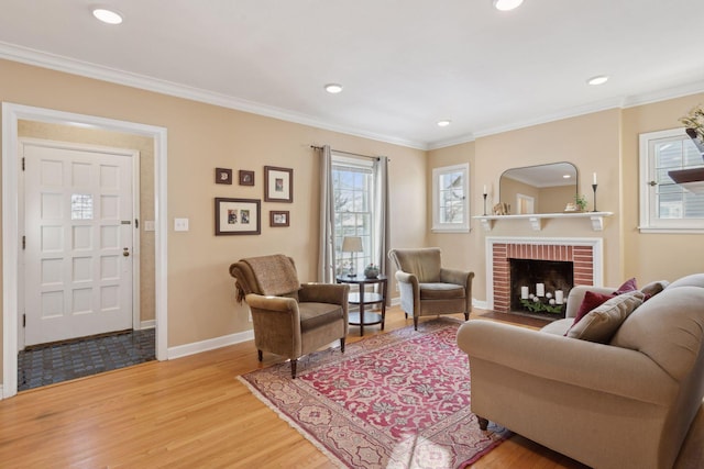 living room featuring a brick fireplace, wood-type flooring, and ornamental molding